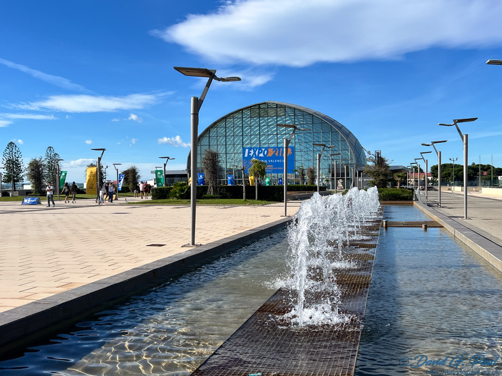 A water feature in front of a curved glass building