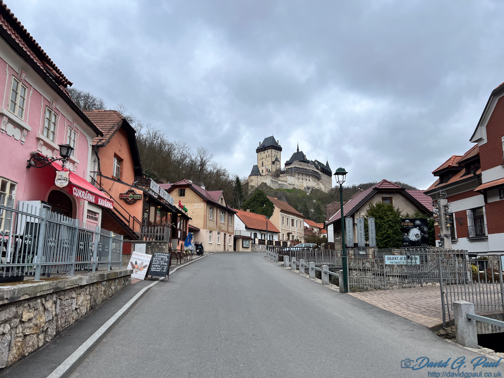 A steep shop-lined road leading up to a castle on the hill