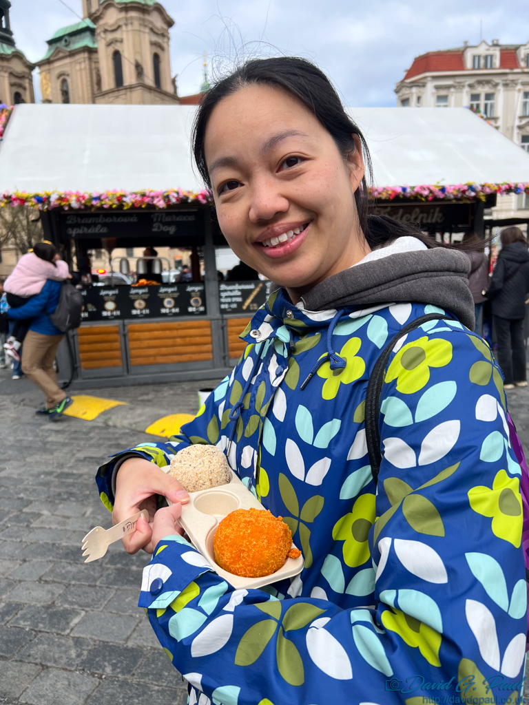 Two knedlin being held in a container in front of a market stall