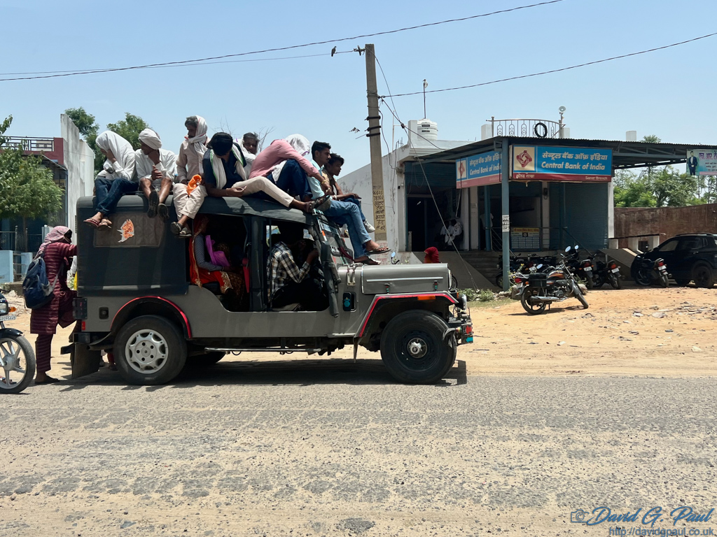 People fill a car, and sit on its roof