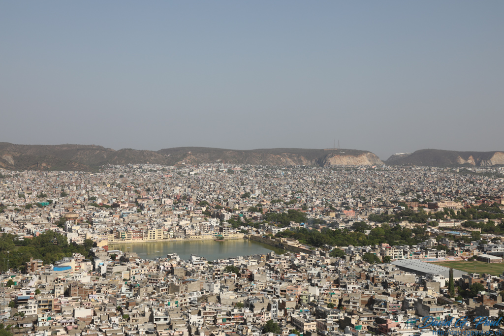 Looking down on many buildings and a lake in Jaipur