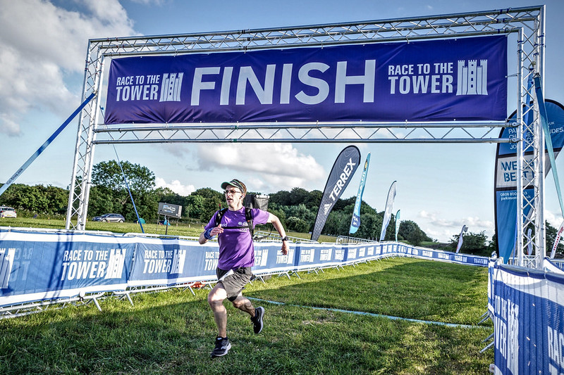 A male runner sprinting over the finish line