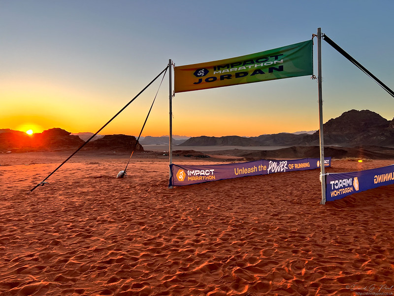 Starting line of the Jordan marathon, the sun is rising behind some rocks