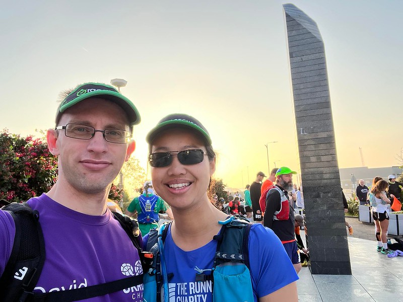 Two runners standing in front of a monument with other runners behind them